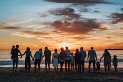 Large family on the beach at sunset