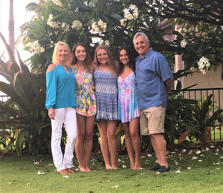 Family posing in front of palm trees 