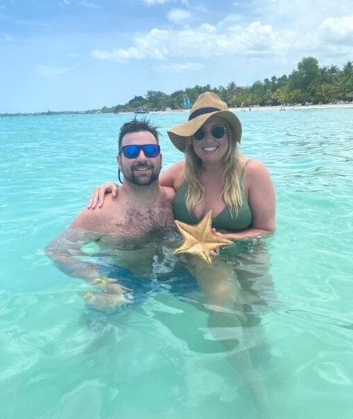 Couple holding starfish in the ocean